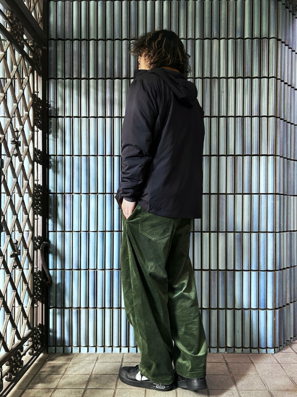 ブラック系のスニーカー、グレー系のニット/セーター、ブラック系のダウンジャケット/コートを着用したメンズの冬コーディネートの4枚目の写真