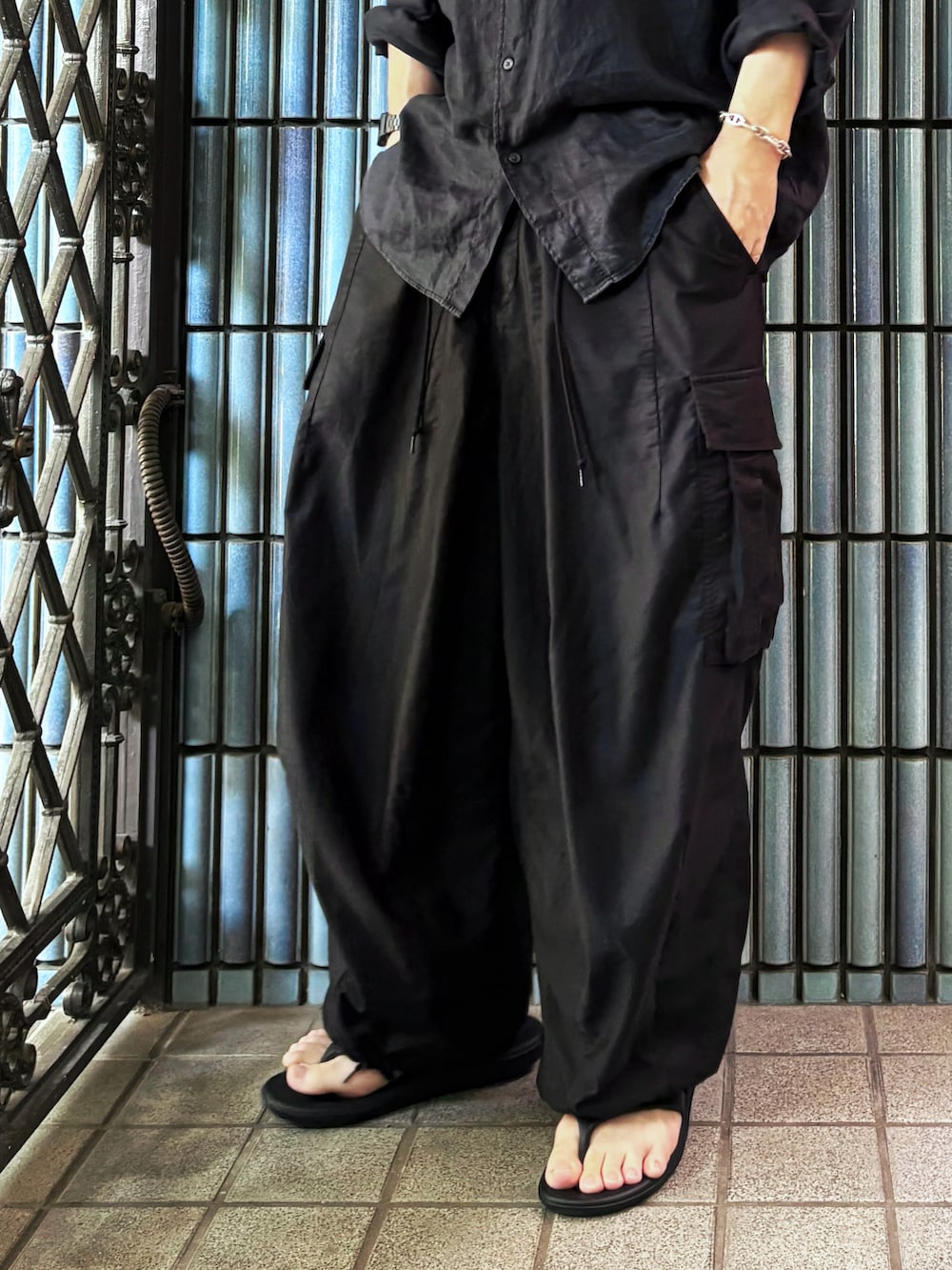 ブラック系のシャツ/ブラウス、ブラック系のサンダル、ブラック系のカーゴパンツを着用したメンズの秋コーディネートの3枚目の写真