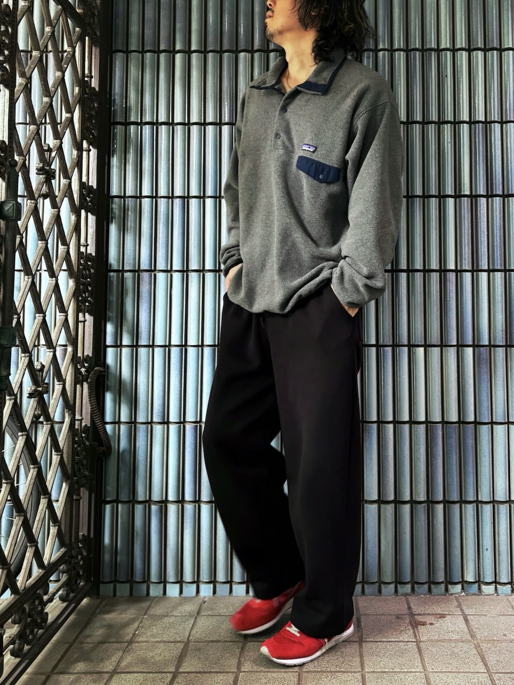 グレー系のニット/セーター、レッド系のスニーカー、ブラック系のスウェットパンツを着用したメンズの春コーディネートの4枚目の写真