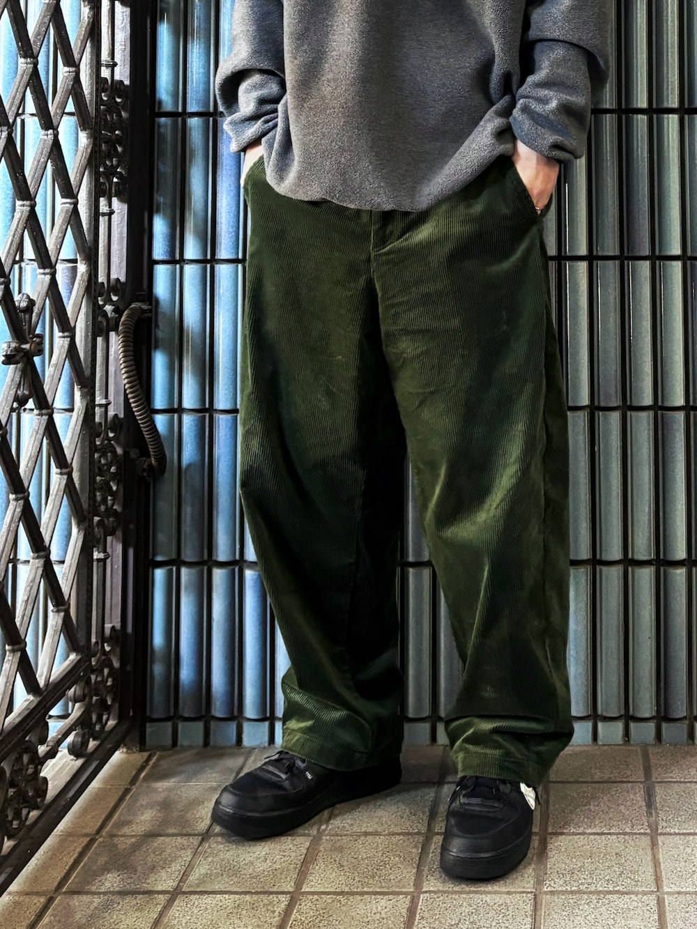 グレー系のニット/セーター、ブラック系のスニーカー、グリーン系のその他パンツを着用したメンズの冬コーディネートの3枚目の写真