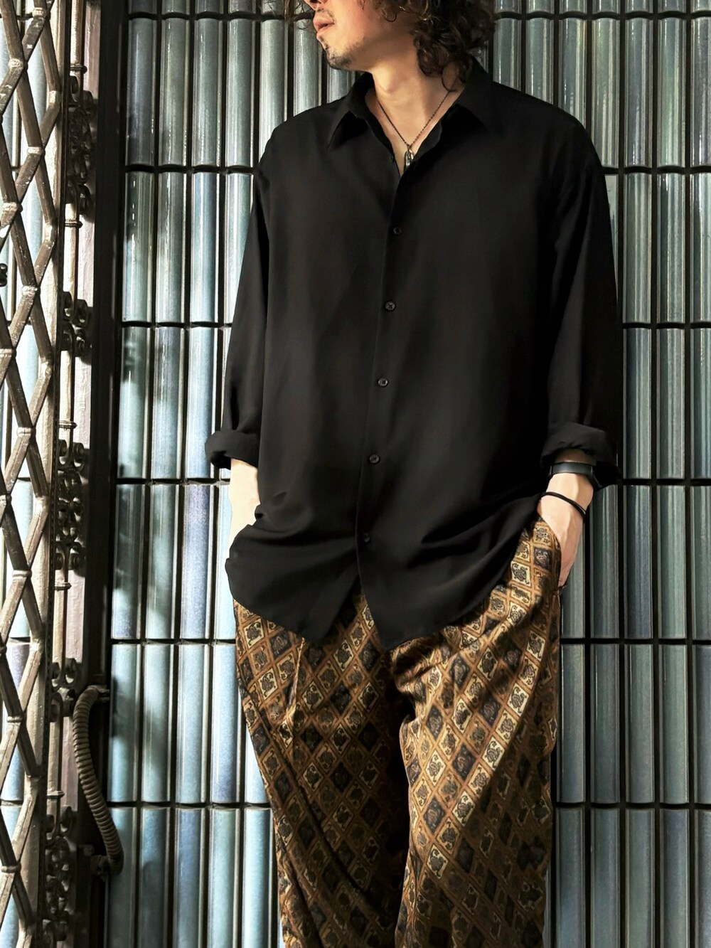 ブラック系のシャツ/ブラウス、ブラウン系のその他パンツ、ブラック系のサンダルを着用したメンズの秋コーディネートの2枚目の写真