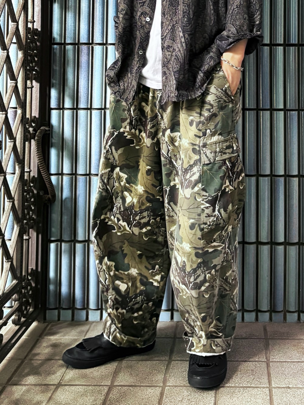 ホワイト系のタンクトップ、グリーン系のカーゴパンツ、グレー系のシャツ/ブラウスを着用したメンズの夏コーディネートの3枚目の写真