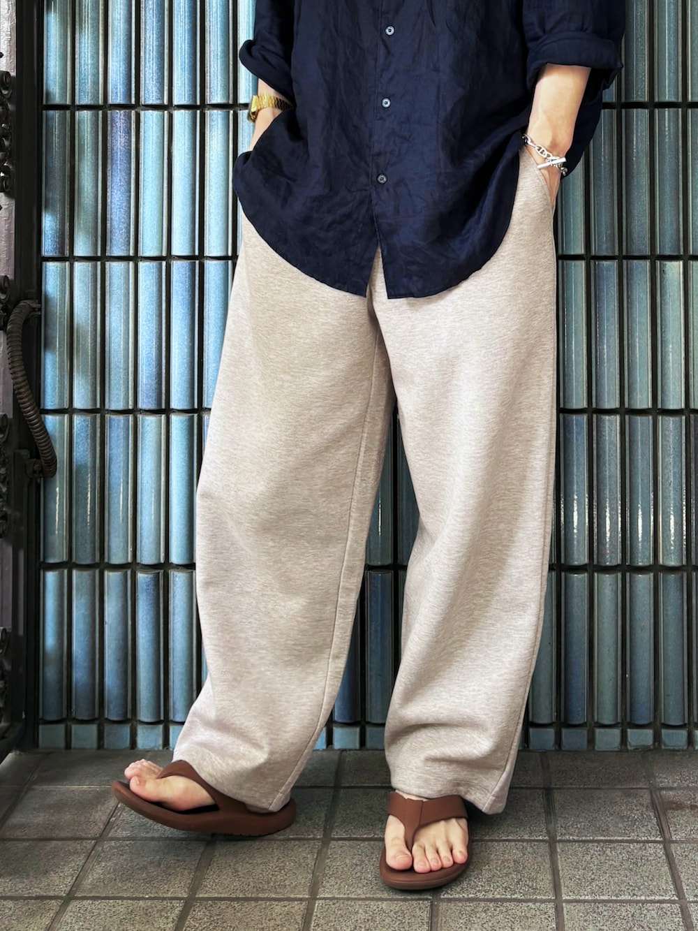 ブラウン系のサンダル、ブルー系のシャツ/ブラウス、ベージュ系のスウェットパンツを着用したメンズの夏コーディネートの3枚目の写真