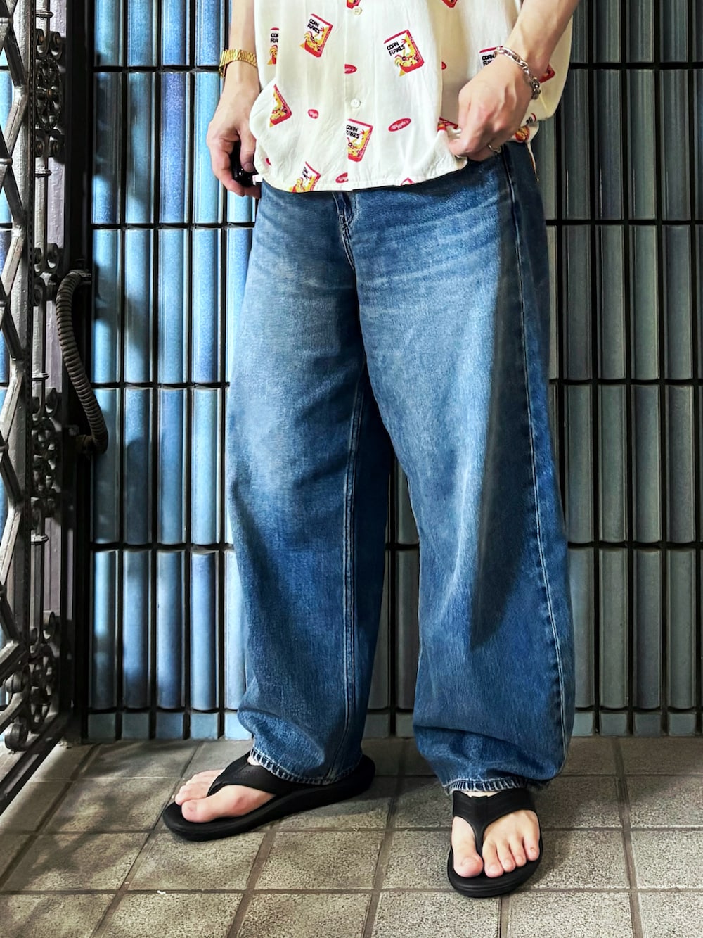 ブラック系のサンダル、ホワイト系のシャツ/ブラウス、ブルー系のデニムパンツを着用したメンズの秋コーディネートの3枚目の写真