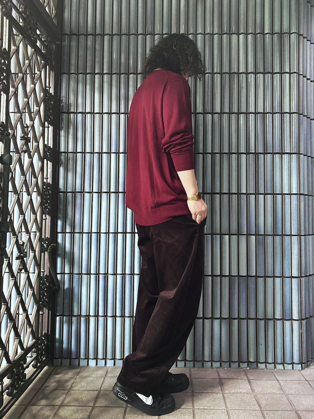 ブラック系のスニーカー、レッド系のニット/セーター、ブラウン系のその他パンツを着用したメンズの冬コーディネートの4枚目の写真