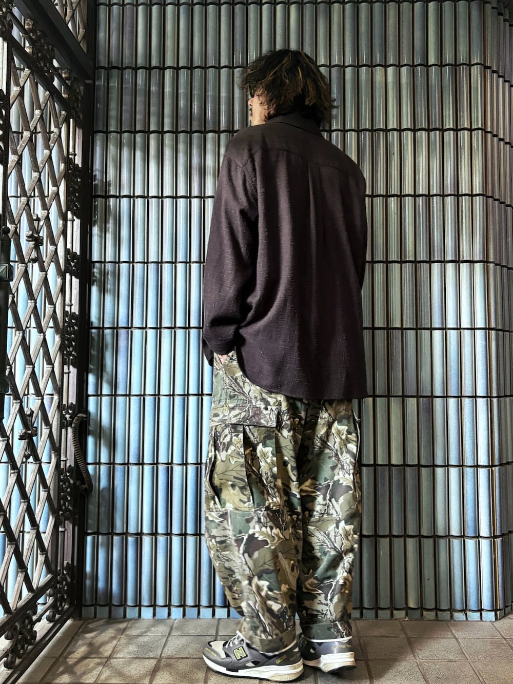 グリーン系のカーゴパンツ、グレー系のスニーカー、ブラック系のシャツ/ブラウスを着用したメンズの秋コーディネートの4枚目の写真