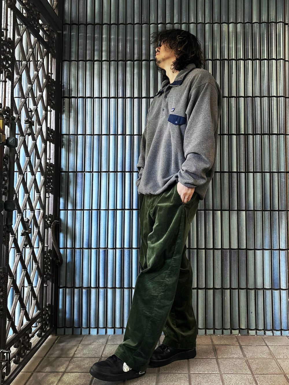 グレー系のニット/セーター、ブラック系のスニーカー、グリーン系のその他パンツを着用したメンズの冬コーディネートの4枚目の写真