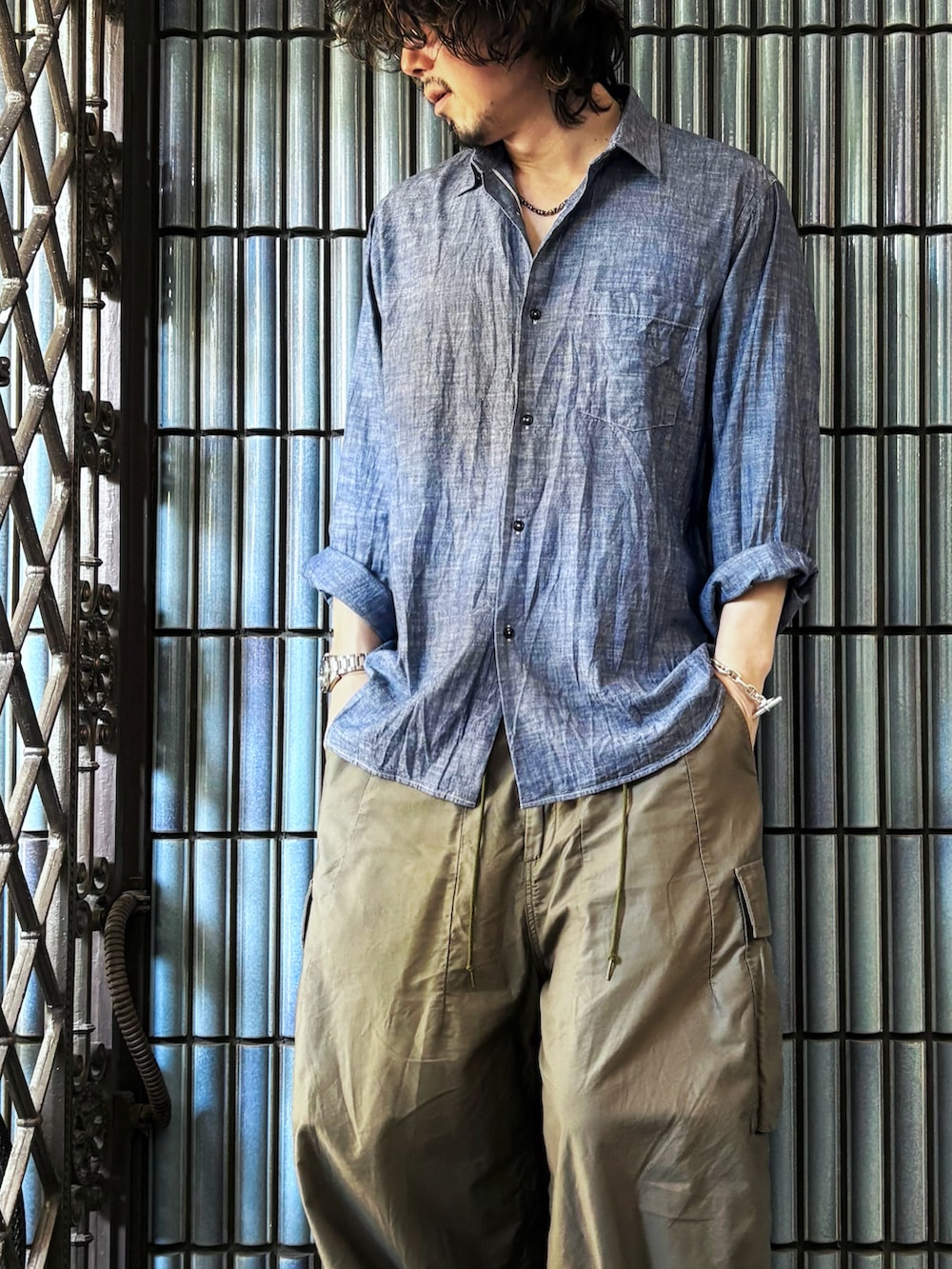 ブルー系のシャツ/ブラウス、グリーン系のカーゴパンツ、ブラック系のローファーを着用したメンズの秋コーディネートの2枚目の写真