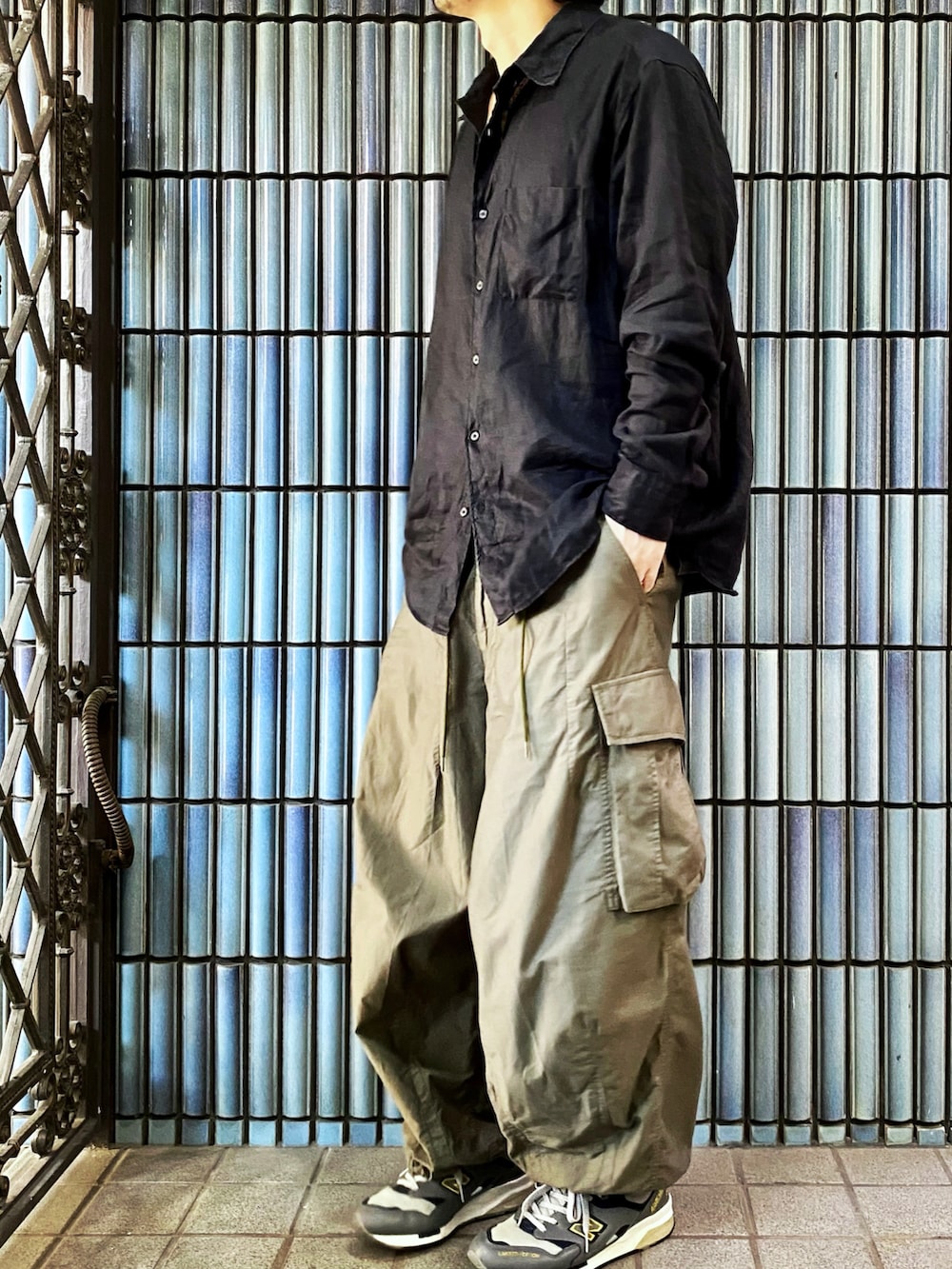 ブラック系のシャツ/ブラウス、グリーン系のカーゴパンツ、グレー系のスニーカーを着用したメンズの秋コーディネートの4枚目の写真