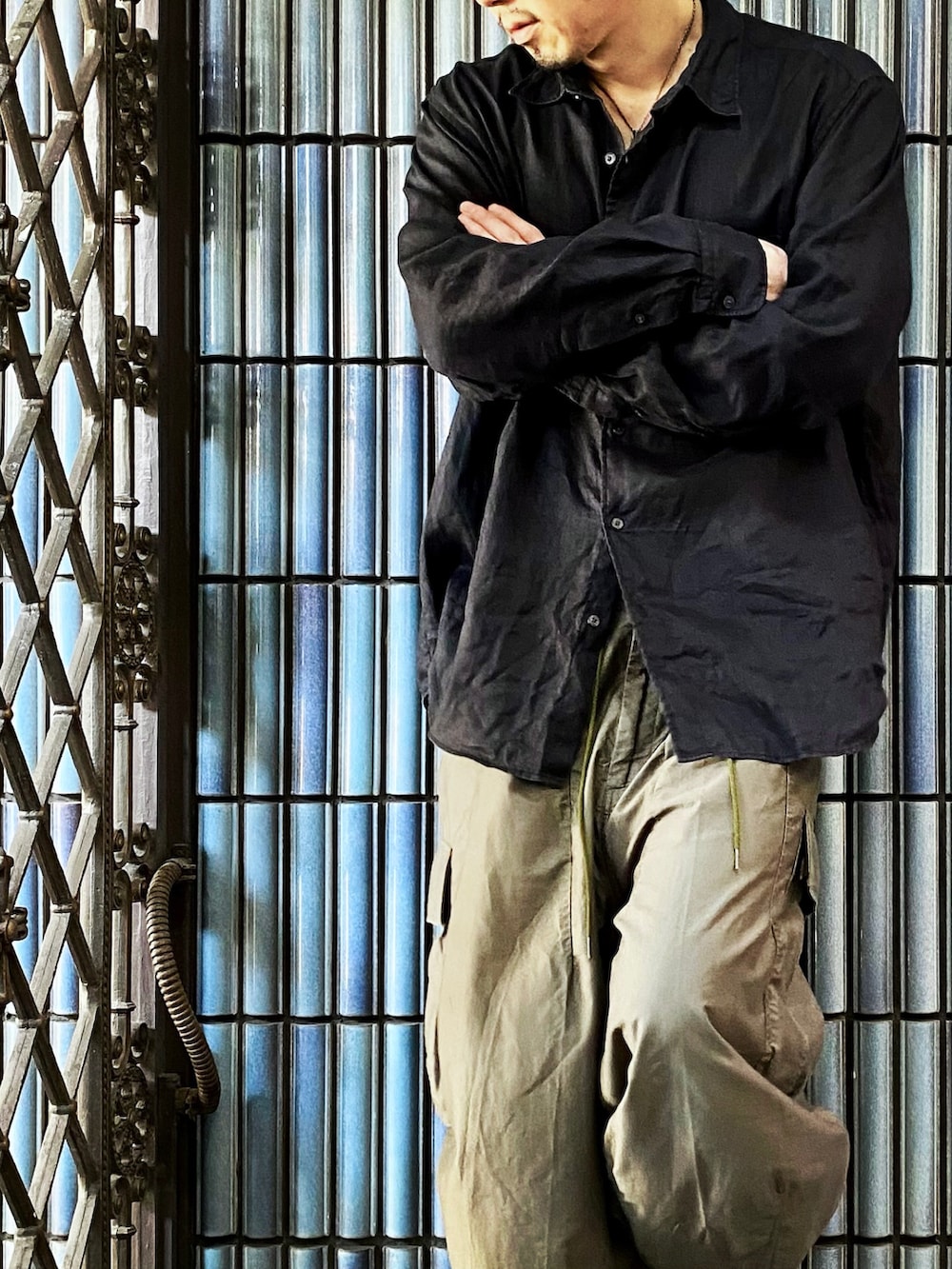 ブラック系のシャツ/ブラウス、グリーン系のカーゴパンツ、グレー系のスニーカーを着用したメンズの秋コーディネートの2枚目の写真