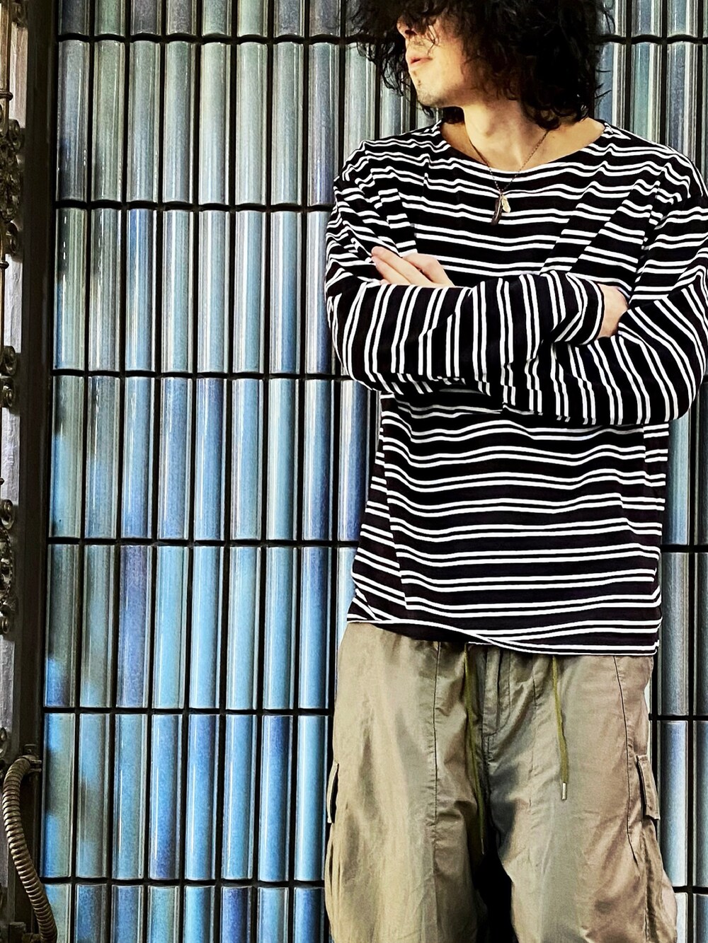 ブラック系のTシャツ/カットソー、グリーン系のカーゴパンツ、グレー系のスニーカーを着用したメンズの秋コーディネートの2枚目の写真