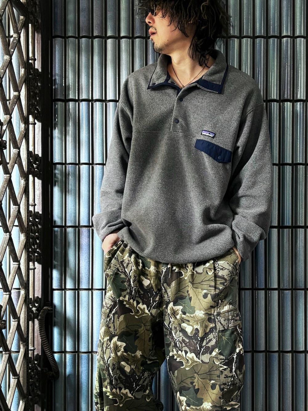 グレー系のニット/セーター、グリーン系のカーゴパンツ、ブラウン系のブーツを着用したメンズの冬コーディネートの2枚目の写真