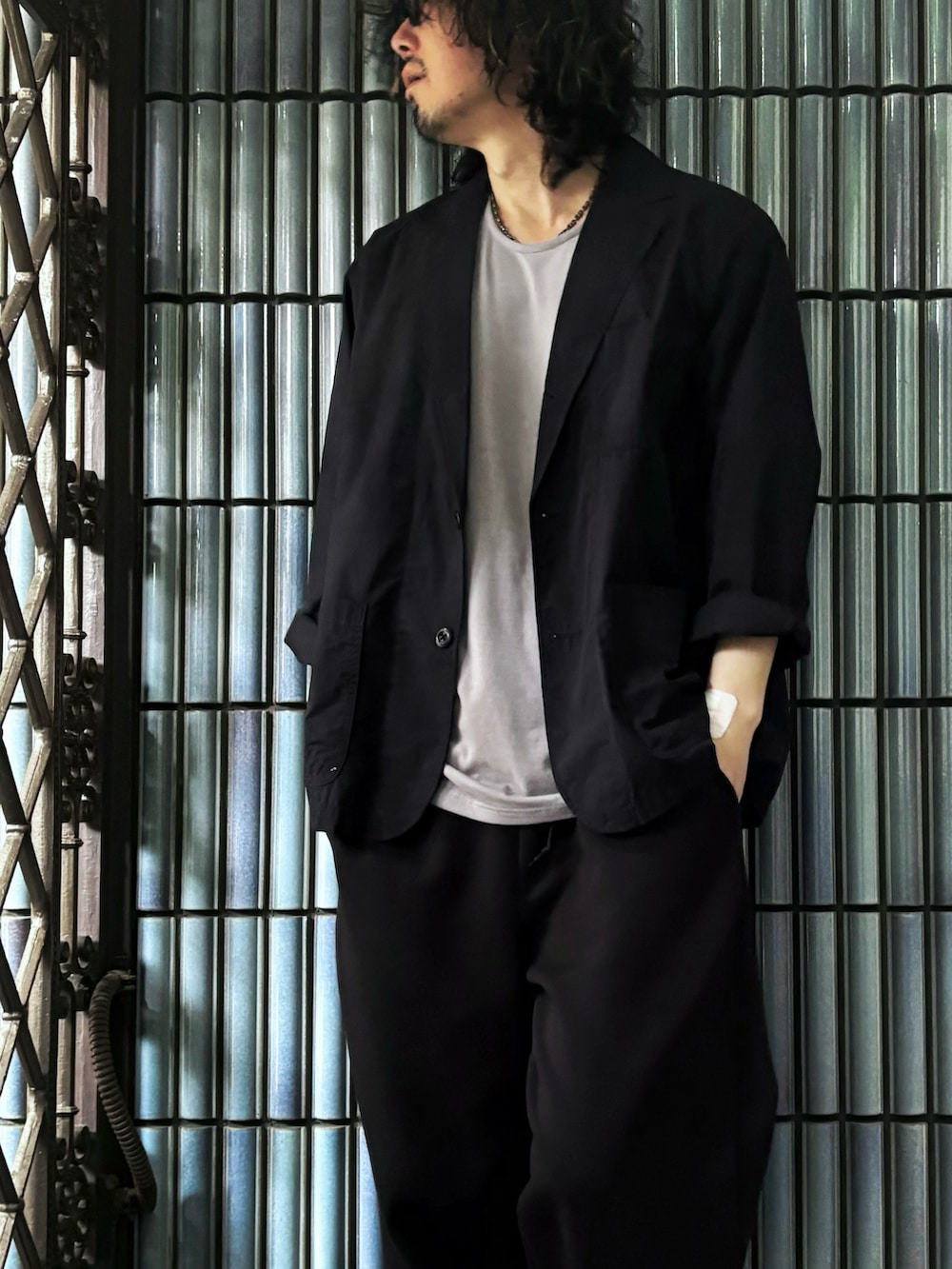 グレー系のスニーカー、グレー系のTシャツ/カットソー、ブラック系のテーラードジャケットを着用したメンズの春コーディネートの2枚目の写真