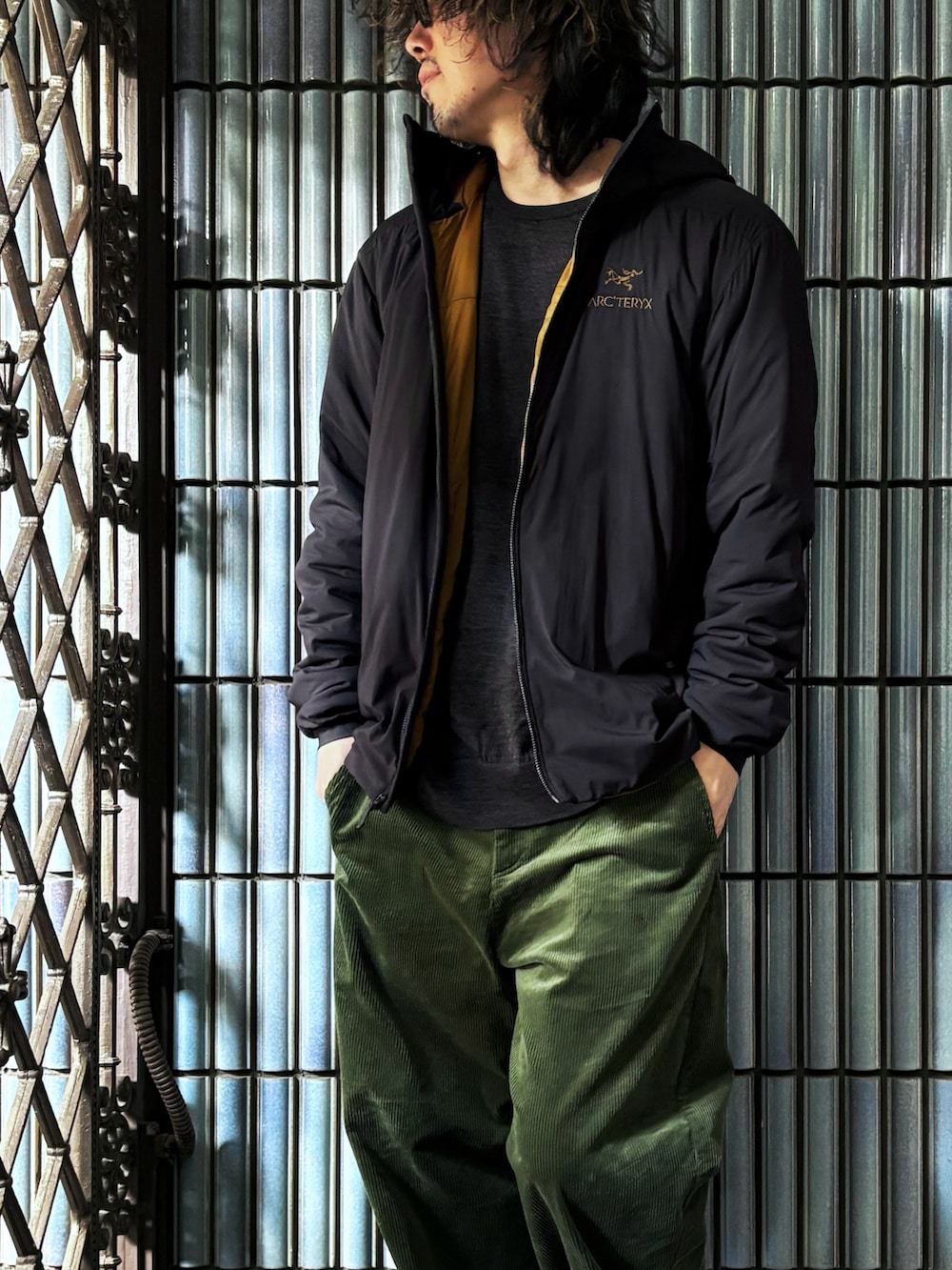 ブラック系のスニーカー、グレー系のニット/セーター、ブラック系のダウンジャケット/コートを着用したメンズの冬コーディネートの2枚目の写真