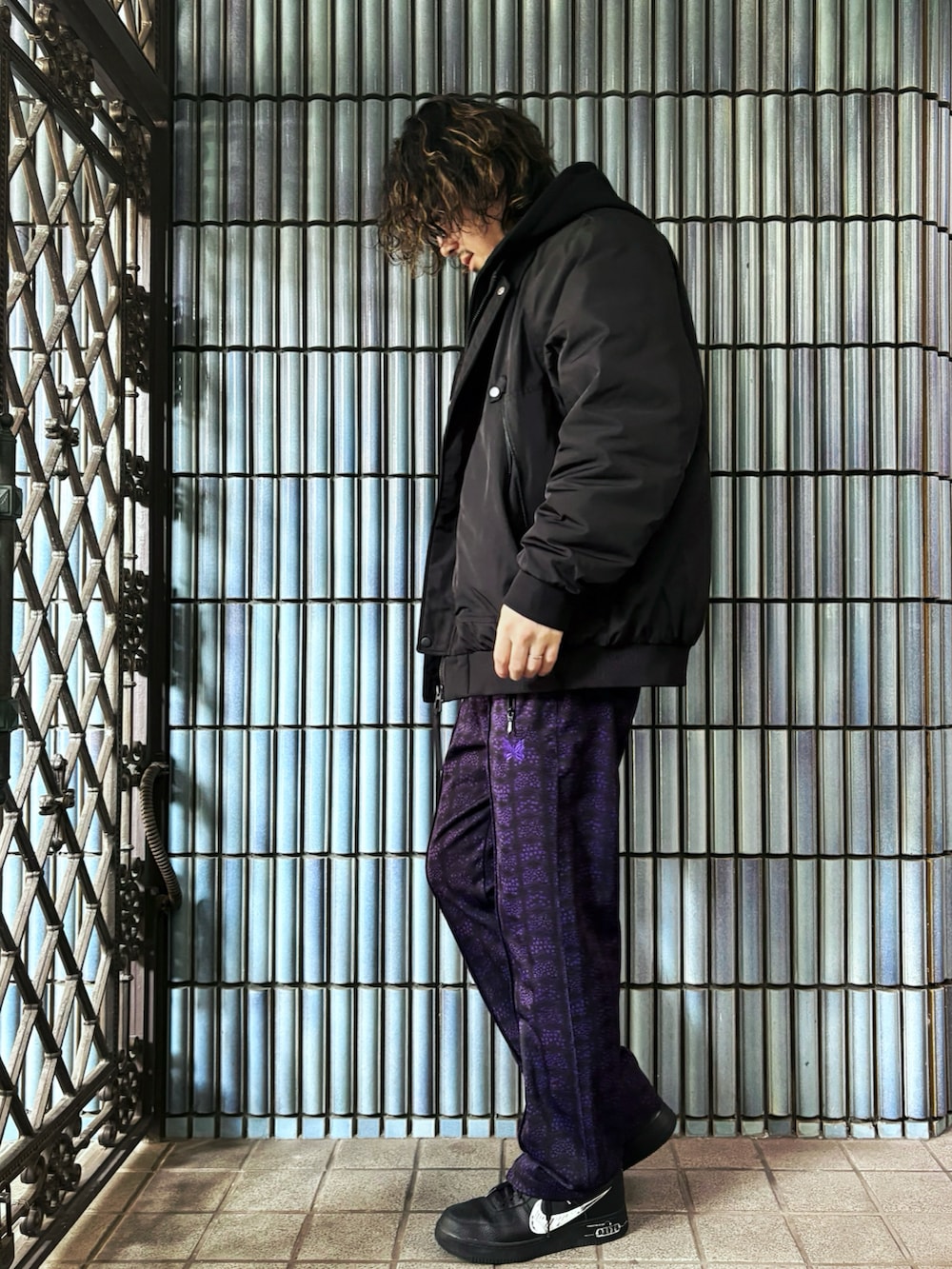 ブラック系のスニーカー、ブラック系のミリタリージャケット、パープル系のその他パンツを着用したメンズの冬コーディネートの4枚目の写真