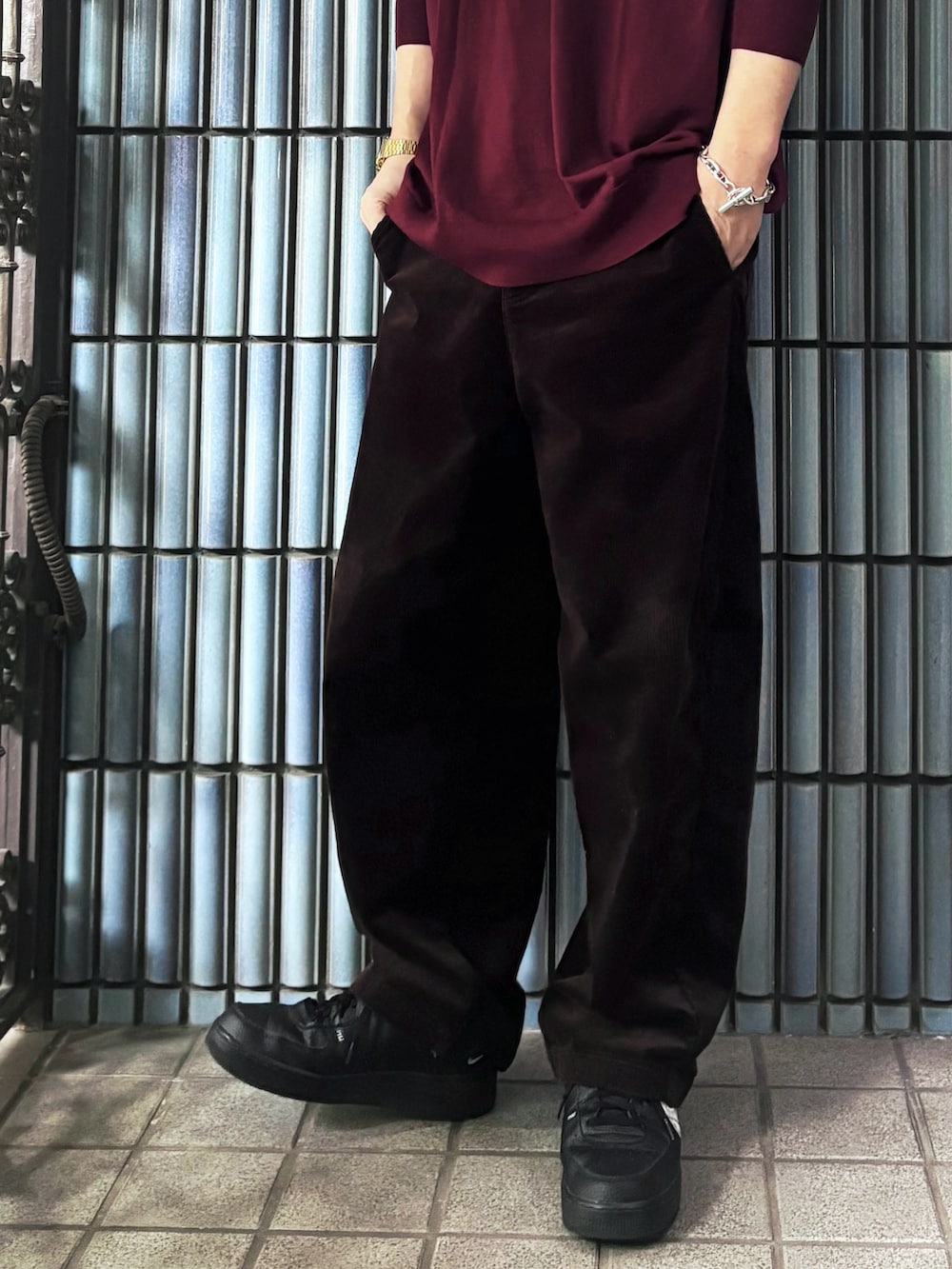 ブラック系のスニーカー、レッド系のニット/セーター、ブラウン系のその他パンツを着用したメンズの冬コーディネートの3枚目の写真