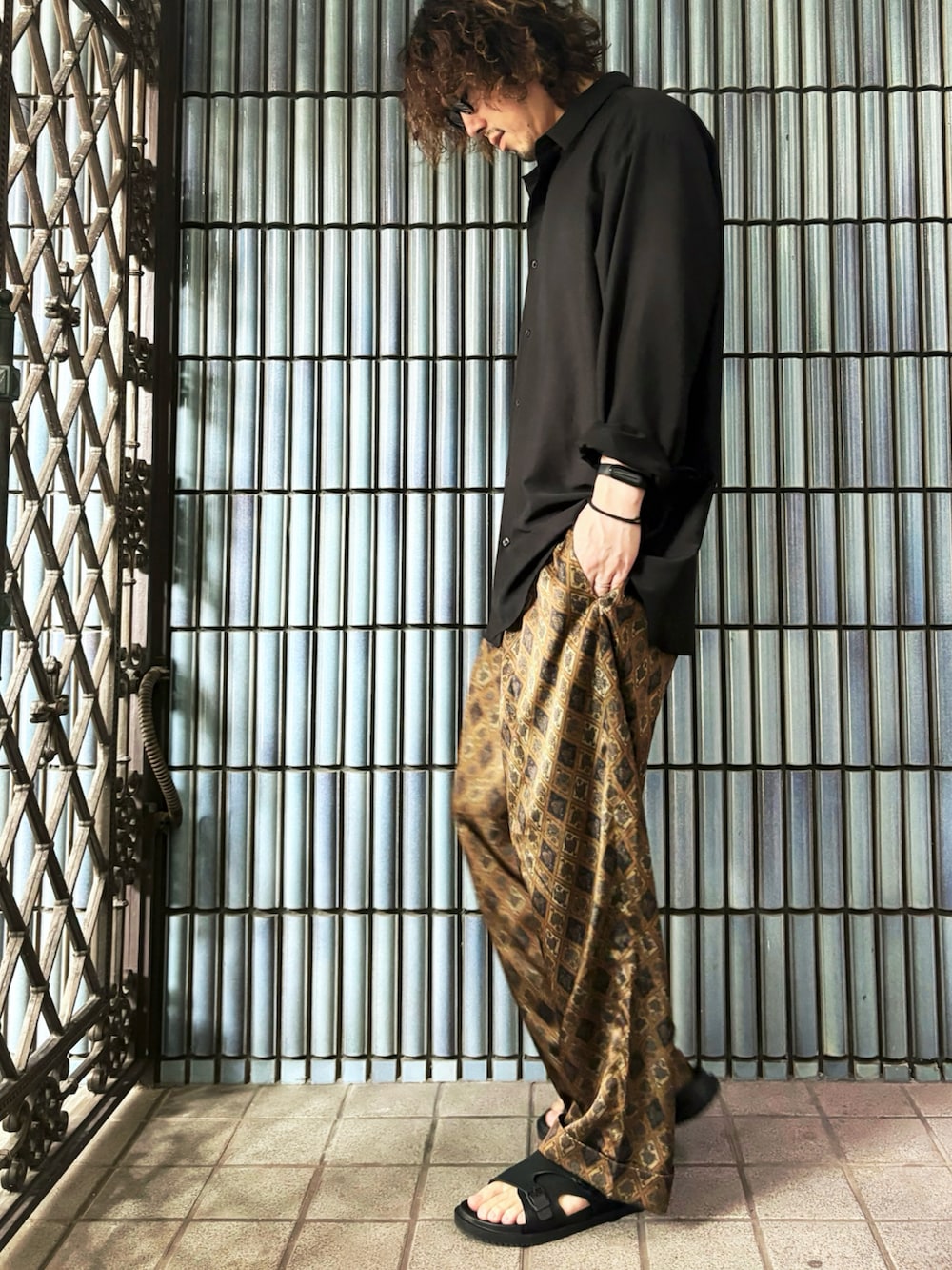 ブラック系のシャツ/ブラウス、ブラウン系のその他パンツ、ブラック系のサンダルを着用したメンズの秋コーディネートの4枚目の写真