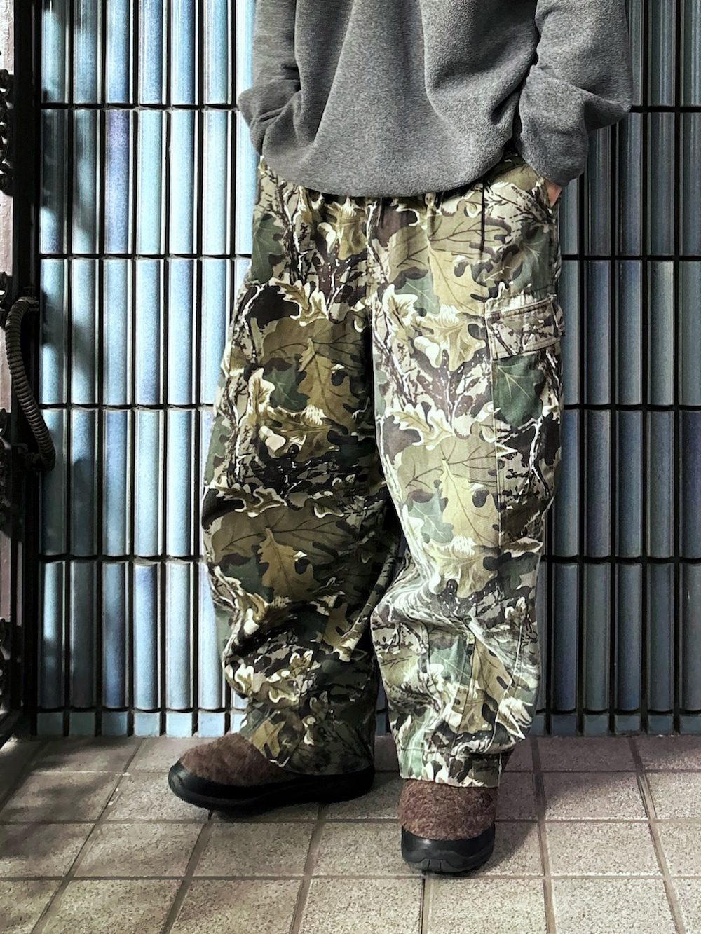 グレー系のニット/セーター、グリーン系のカーゴパンツ、ブラウン系のブーツを着用したメンズの冬コーディネートの3枚目の写真