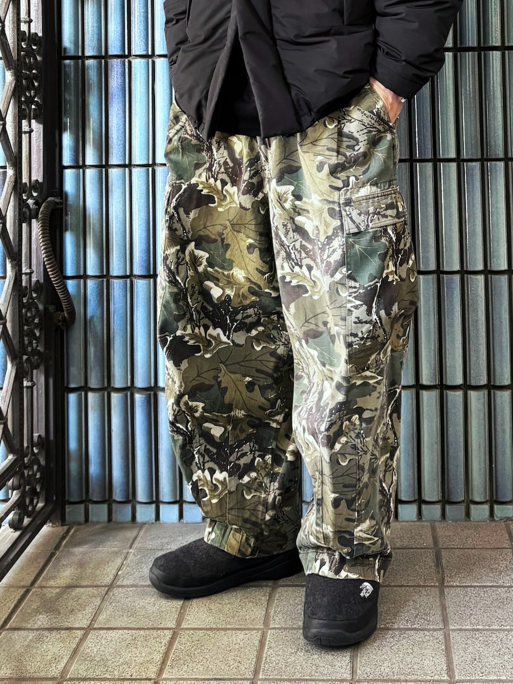 グリーン系のカーゴパンツ、ブラック系のダウンジャケット/コート、グレー系のブーツを着用したメンズの冬コーディネートの3枚目の写真