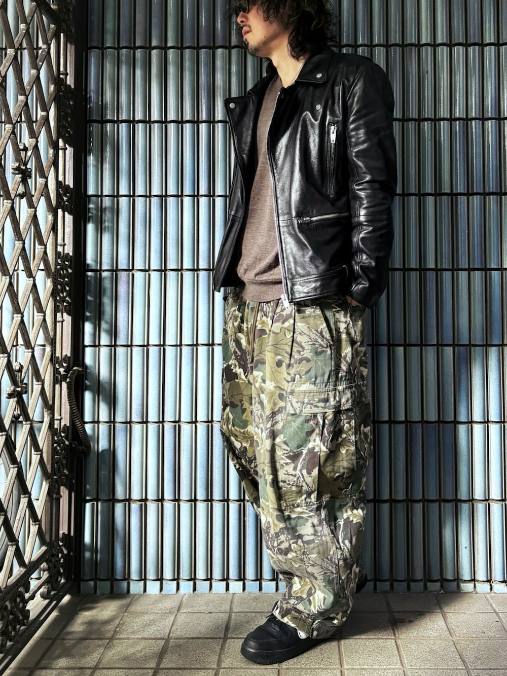 ブラウン系のニット/セーター、グリーン系のカーゴパンツ、ブラック系のスニーカーを着用したメンズの春コーディネートの4枚目の写真