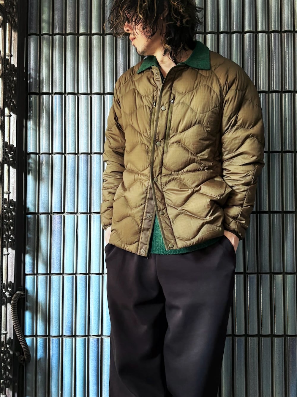 グリーン系のニット/セーター、グリーン系のダウンジャケット/コート、ブラック系のスウェットパンツを着用したメンズの冬コーディネートの2枚目の写真