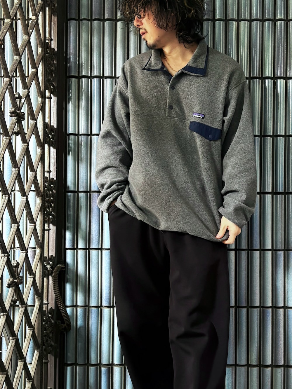 グレー系のニット/セーター、レッド系のスニーカー、ブラック系のスウェットパンツを着用したメンズの春コーディネートの2枚目の写真