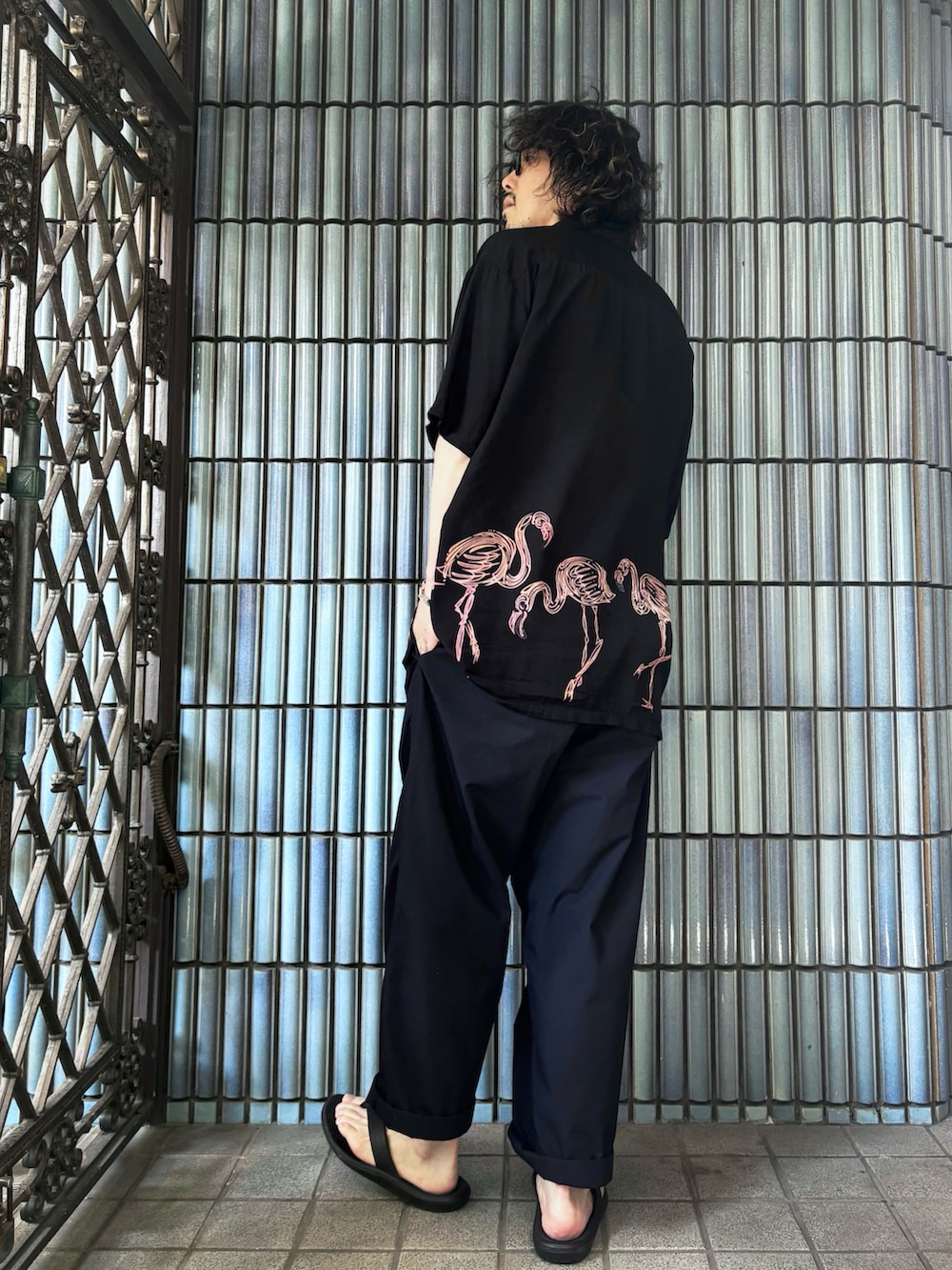 ブラック系のサンダル、ブラック系のシャツ/ブラウス、ブルー系のスラックスを着用したメンズの夏コーディネートの4枚目の写真