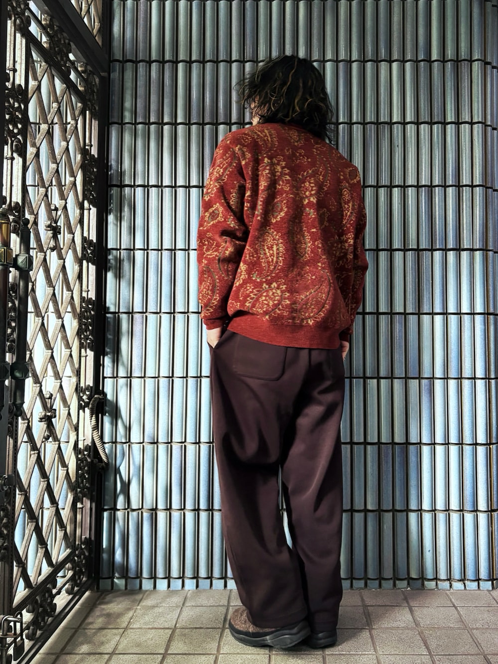 レッド系のカーディガン/ボレロ、ブラウン系のニット/セーター、ブラウン系のスウェットパンツを着用したメンズの冬コーディネートの4枚目の写真