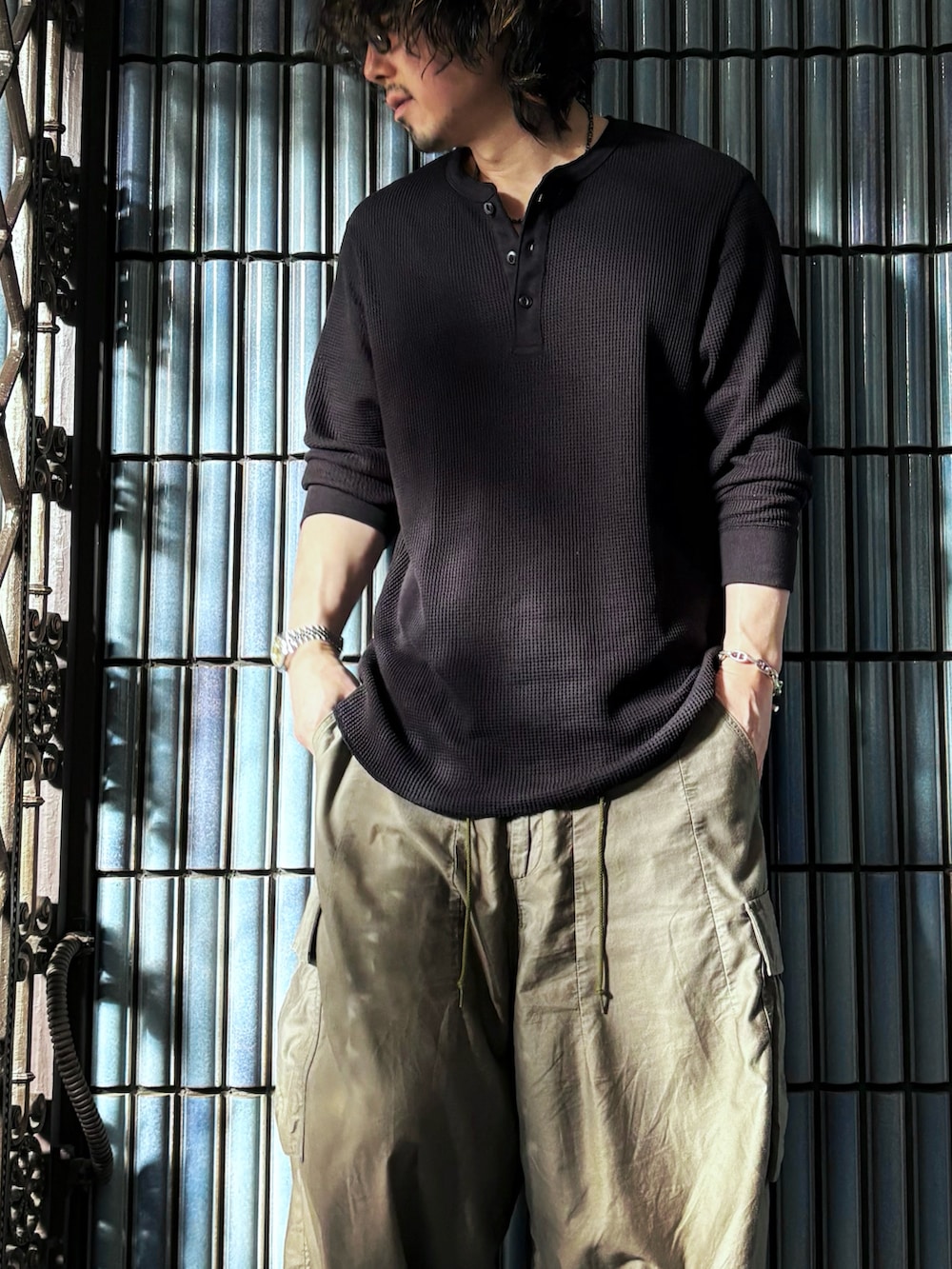 ブラック系のスニーカー、ブラック系のTシャツ/カットソー、グリーン系のカーゴパンツを着用したメンズの秋コーディネートの2枚目の写真