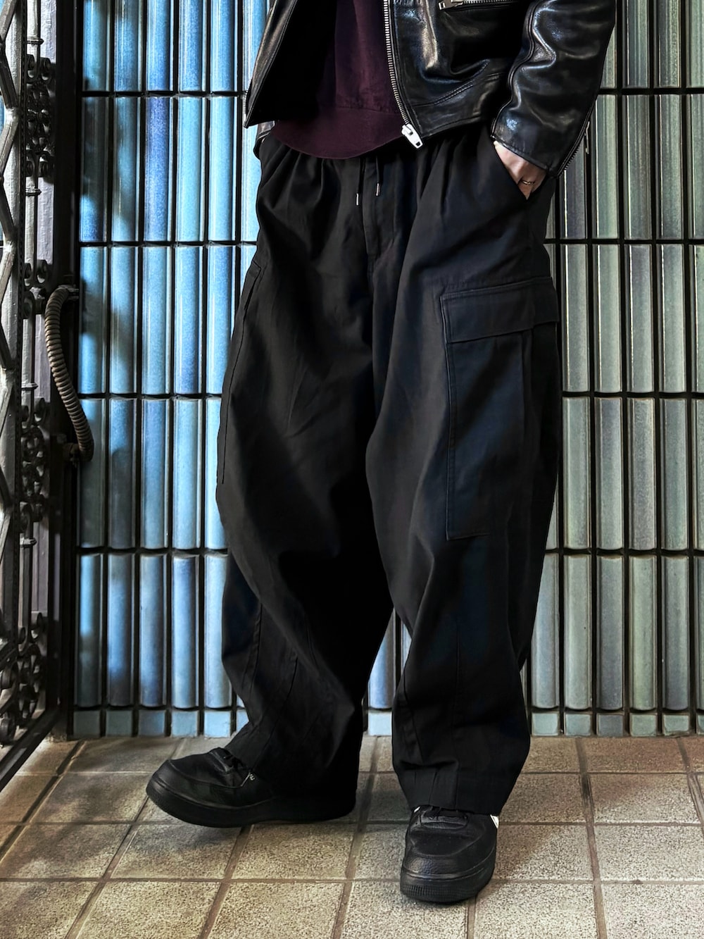 ブラック系のカーゴパンツ、ブラック系のスニーカー、パープル系のニット/セーターを着用したメンズの冬コーディネートの3枚目の写真