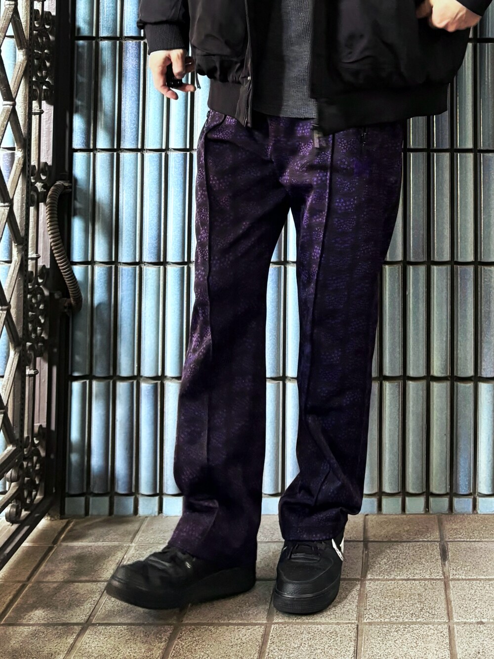 ブラック系のスニーカー、ブラック系のミリタリージャケット、パープル系のその他パンツを着用したメンズの冬コーディネートの3枚目の写真