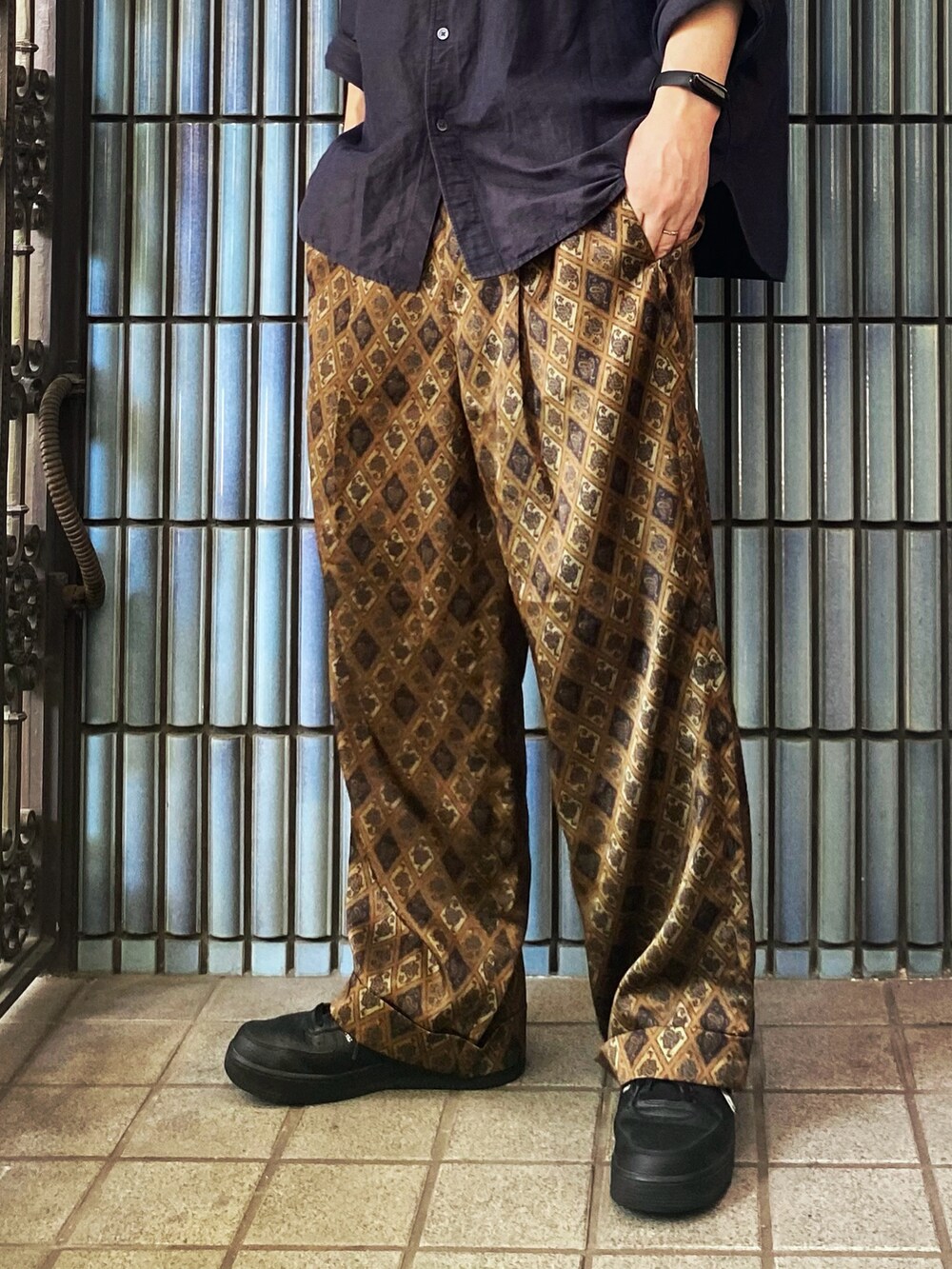 ブルー系のシャツ/ブラウス、ブラウン系のその他パンツ、ブラック系のスニーカーを着用したメンズの夏コーディネートの3枚目の写真