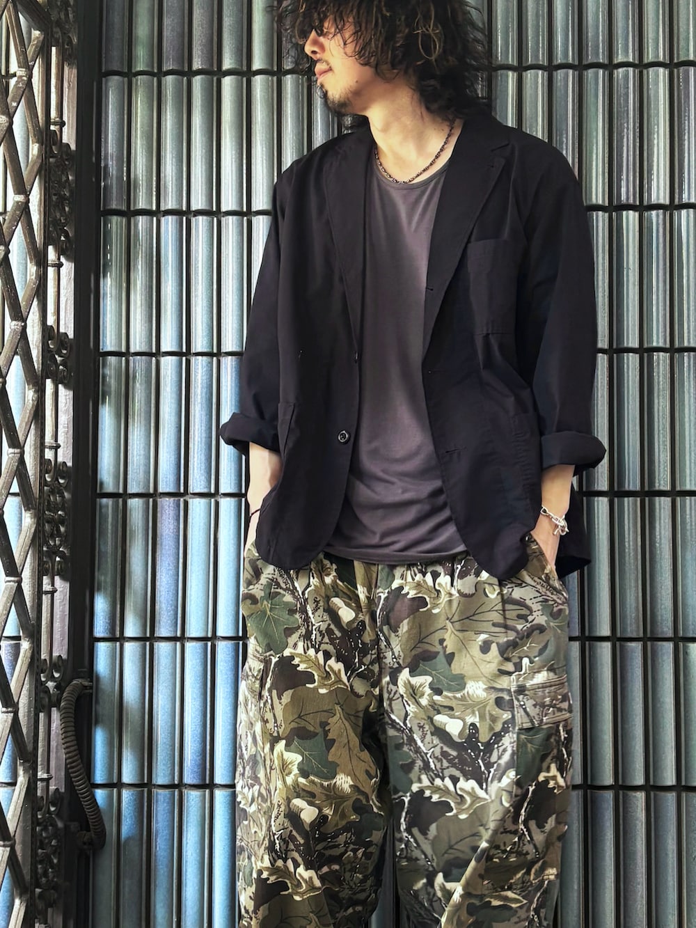 グリーン系のカーゴパンツ、ブラック系のスニーカー、グレー系のTシャツ/カットソーを着用したメンズの春コーディネートの2枚目の写真