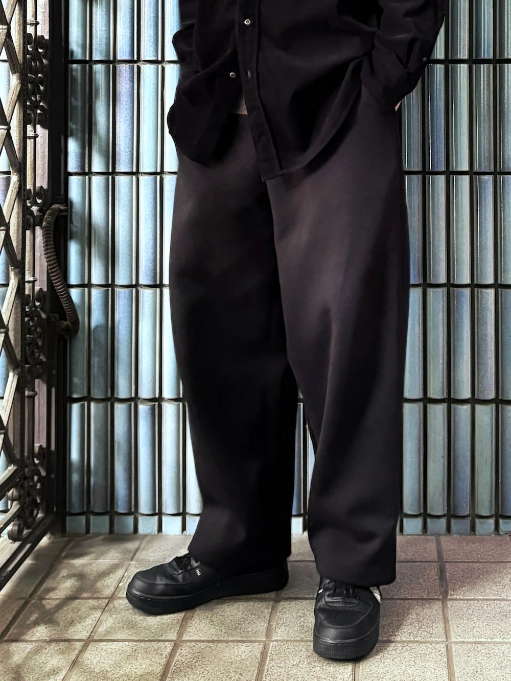 ブラウン系のニット/セーター、ブラック系のスニーカー、ブラック系のシャツ/ブラウスを着用したメンズの春コーディネートの3枚目の写真