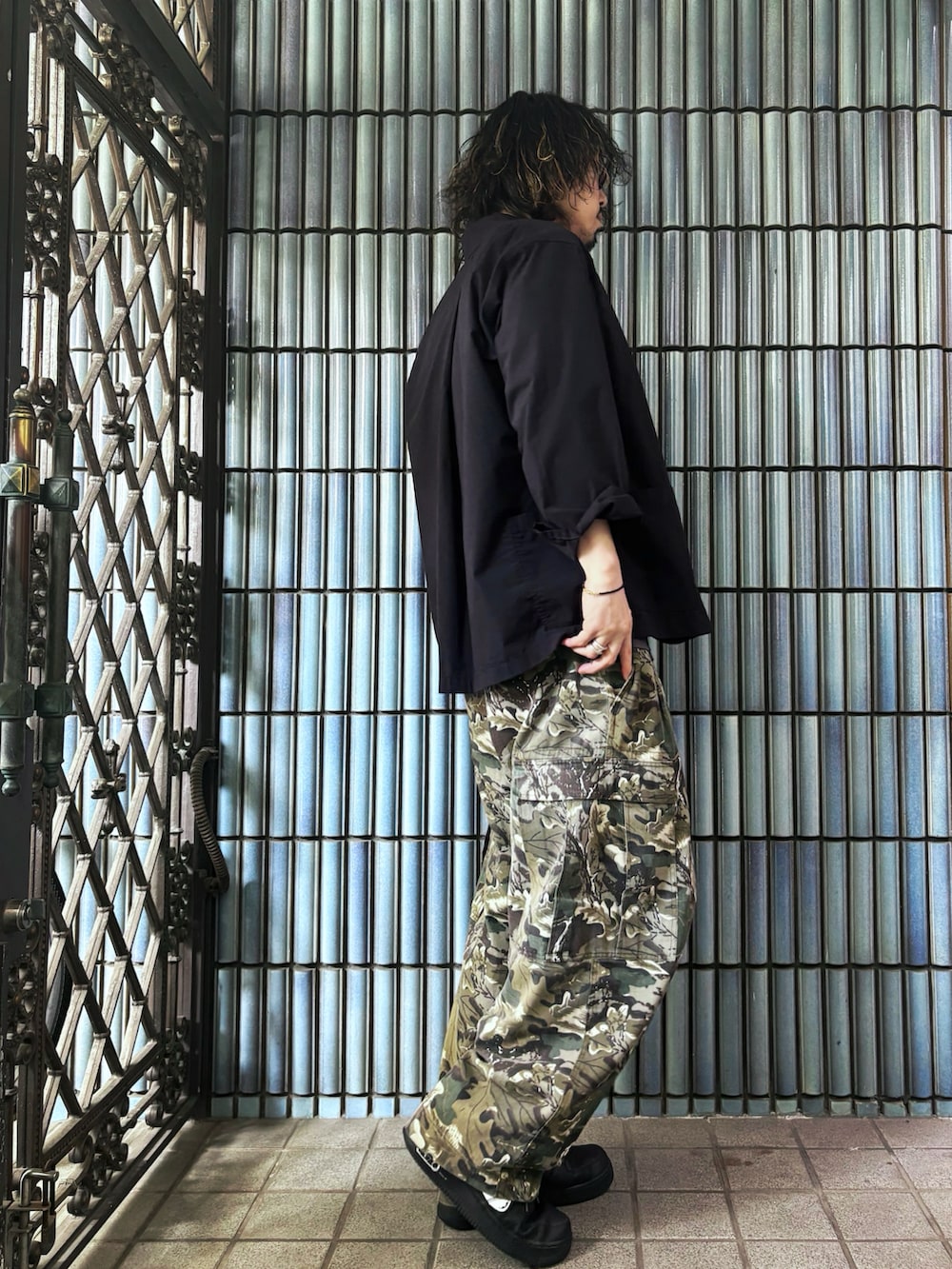 グリーン系のカーゴパンツ、ブラック系のスニーカー、グレー系のTシャツ/カットソーを着用したメンズの春コーディネートの4枚目の写真