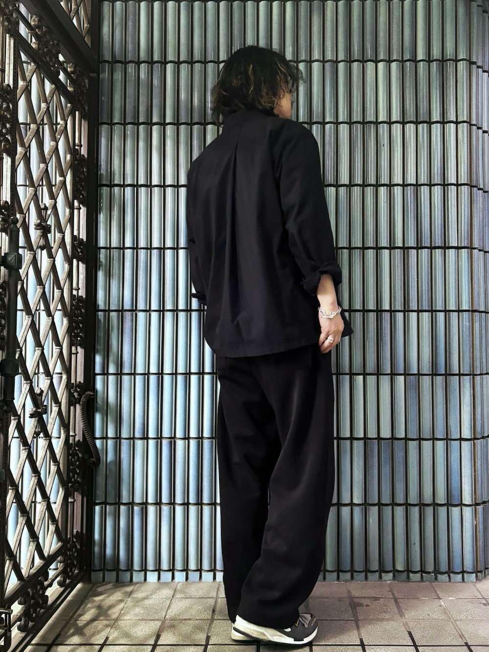 グレー系のスニーカー、グレー系のTシャツ/カットソー、ブラック系のテーラードジャケットを着用したメンズの春コーディネートの4枚目の写真