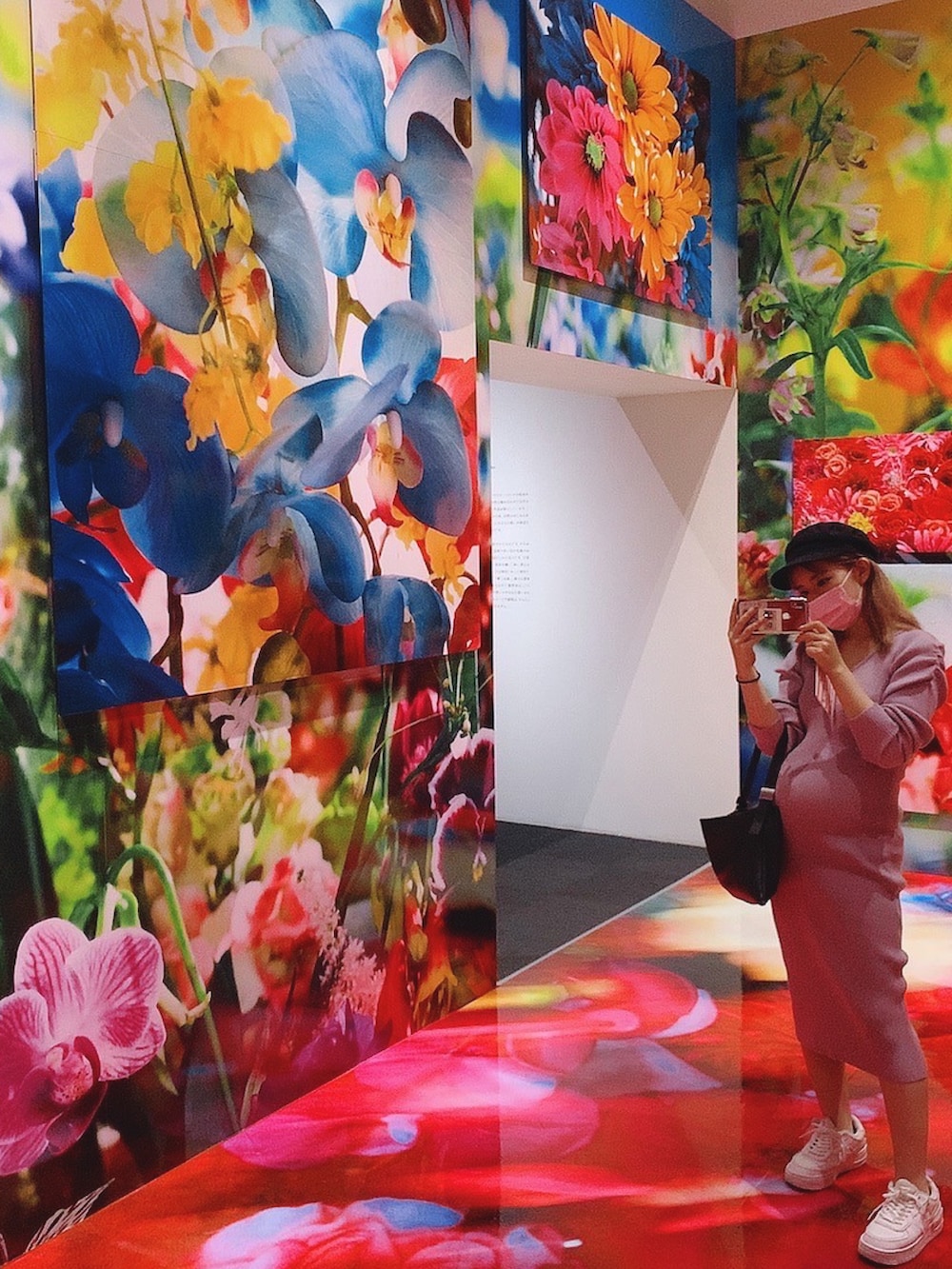 パープル系のワンピース、ホワイト系のスニーカー、ブラック系のハンドバッグを着用したレディースの秋コーディネートの3枚目の写真