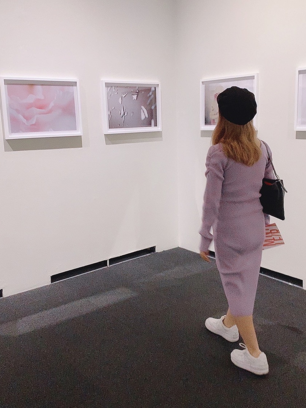 パープル系のワンピース、ホワイト系のスニーカー、ブラック系のハンドバッグを着用したレディースの秋コーディネートの2枚目の写真