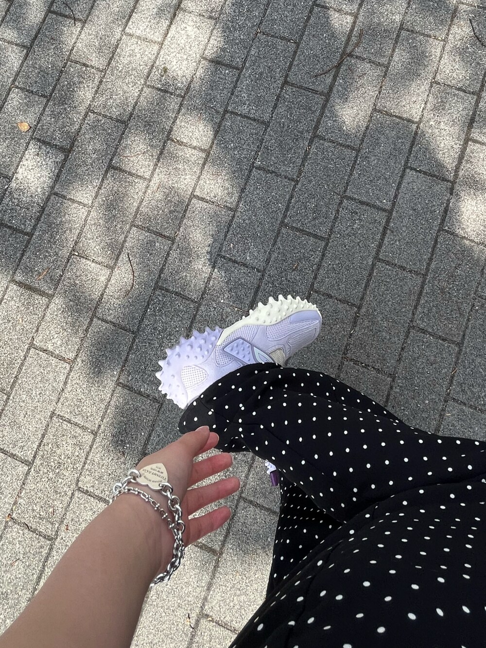 ブラック系のトートバッグ、ブラック系のワンピース、パープル系のシューズを着用したレディースの春コーディネートの2枚目の写真