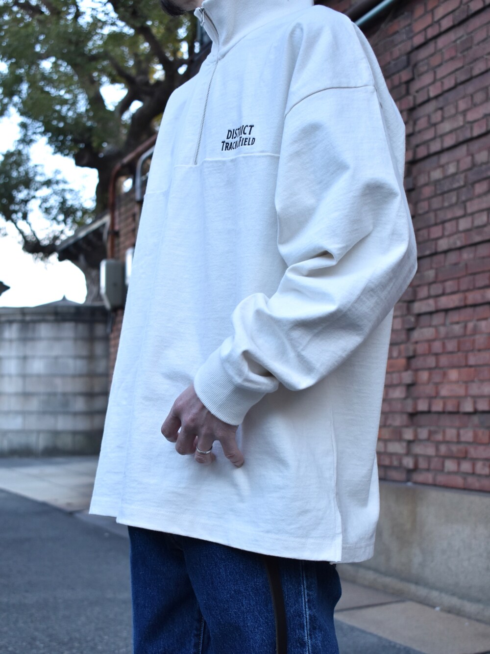 ホワイト系のTシャツ/カットソー、ブルー系のデニムパンツ、ホワイト系のスニーカーを着用したメンズの春コーディネートの2枚目の写真