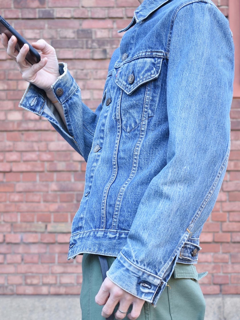 ブルー系のデニムジャケット、グリーン系のその他パンツ、ブラック系のシューズを着用したメンズの冬コーディネートの2枚目の写真