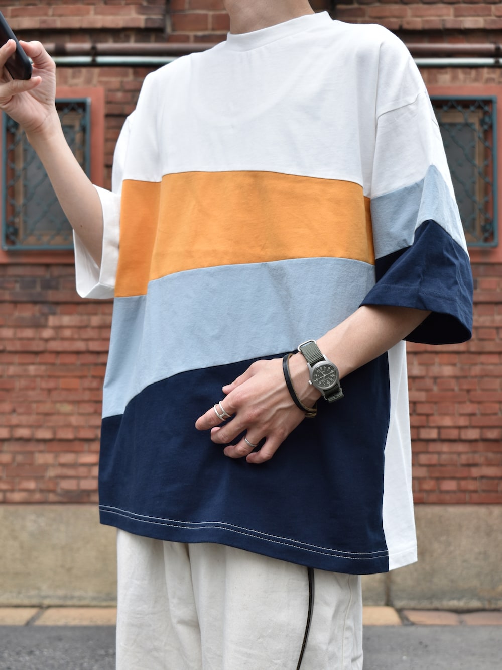 ホワイト系のTシャツ/カットソー、ホワイト系のパンツ、ブラック系のサンダルを着用したメンズの夏コーディネートの2枚目の写真