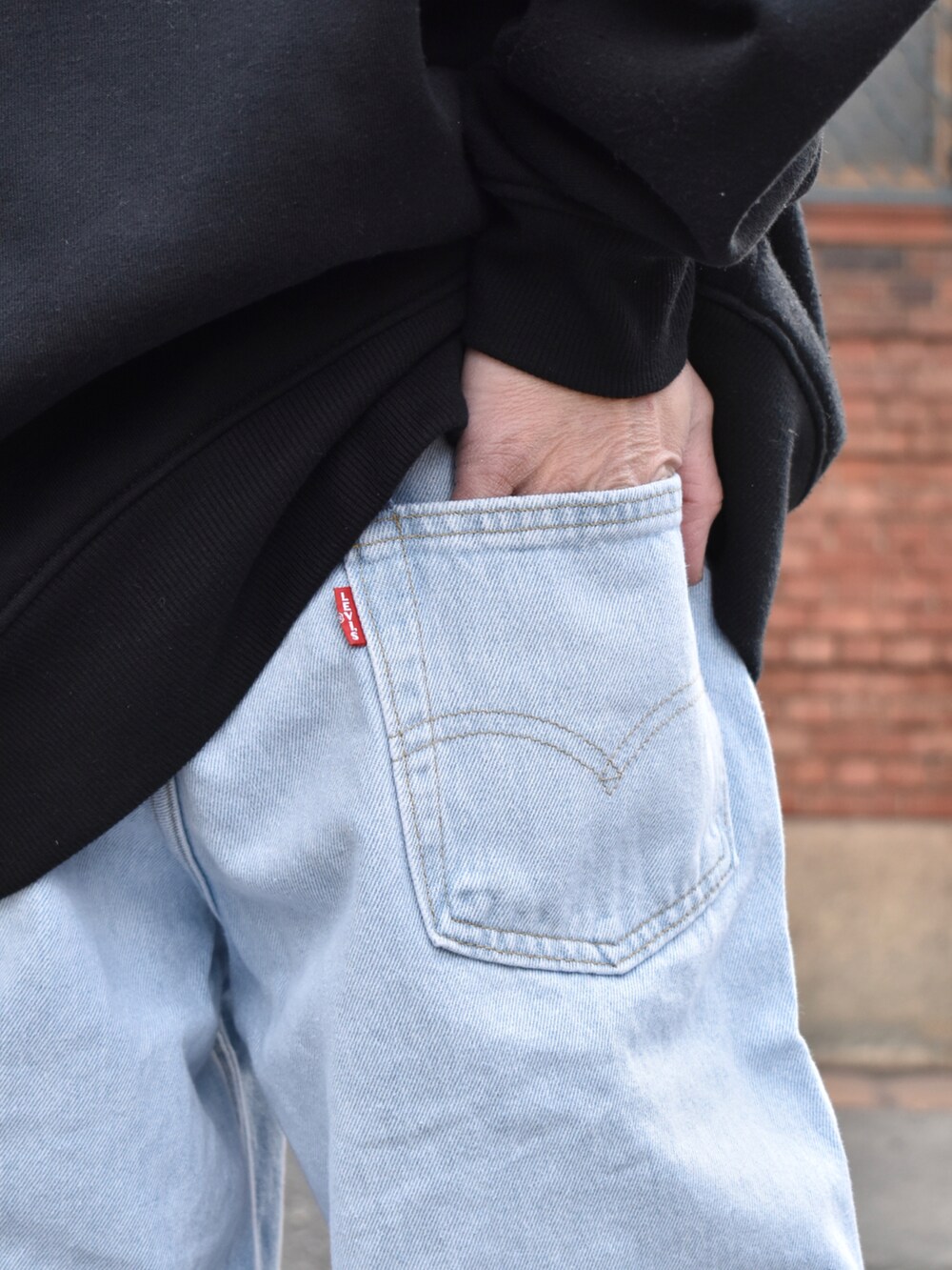 ブルー系のデニムパンツ、ブラック系のスニーカー、グレー系のニットキャップ/ビーニーを着用したメンズの冬コーディネートの3枚目の写真