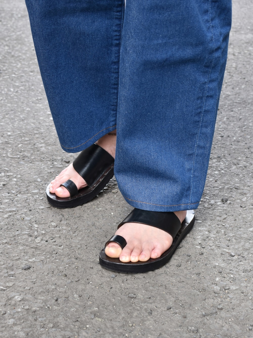 グレー系のTシャツ/カットソー、ブルー系のデニムパンツ、ブラック系のサンダルを着用したメンズの夏コーディネートの3枚目の写真