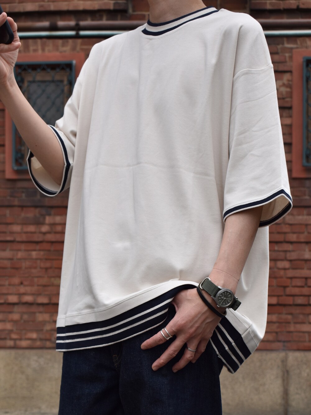 ベージュ系のTシャツ/カットソー、ブルー系のデニムパンツ、ブラック系のモカシン/デッキシューズを着用したメンズの春コーディネートの2枚目の写真