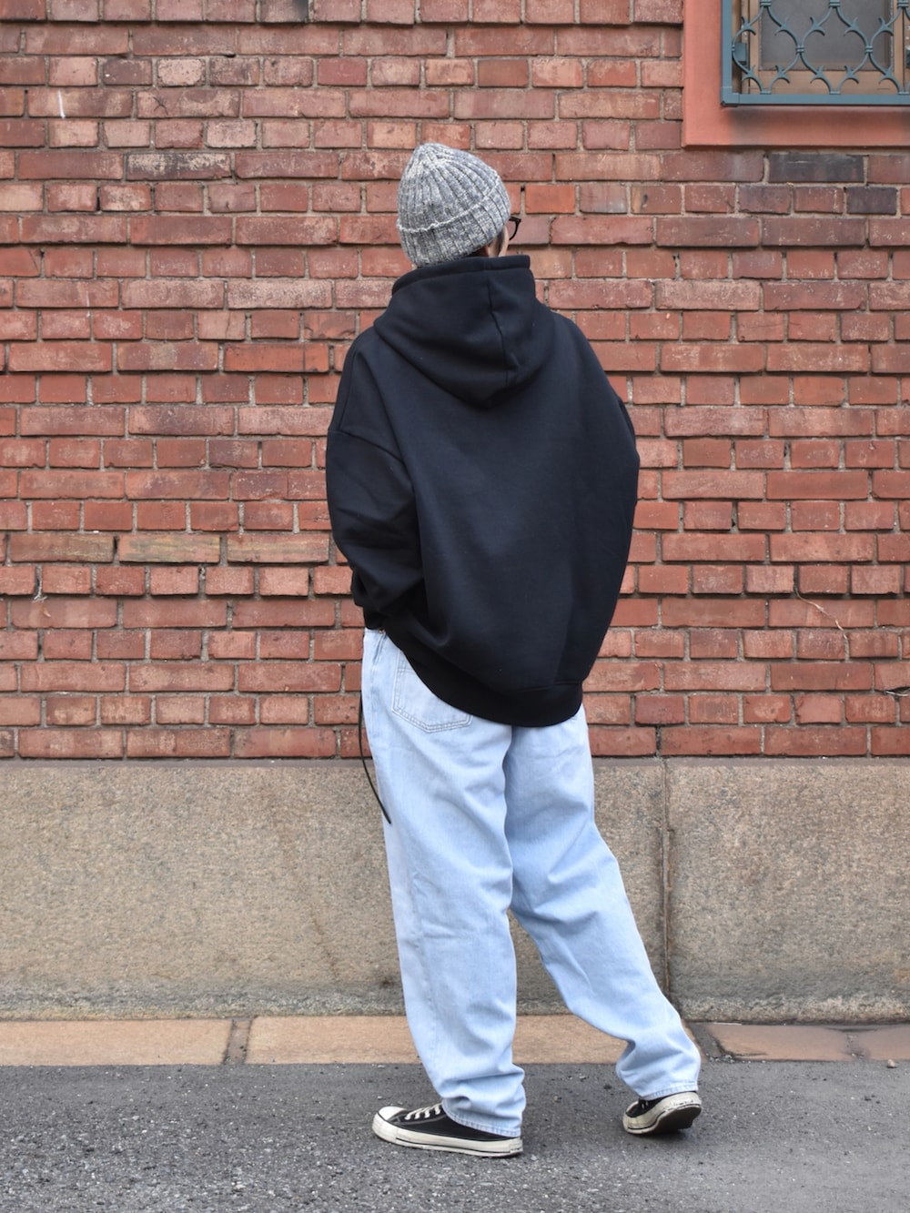 ブルー系のデニムパンツ、ブラック系のスニーカー、グレー系のニットキャップ/ビーニーを着用したメンズの冬コーディネートの2枚目の写真