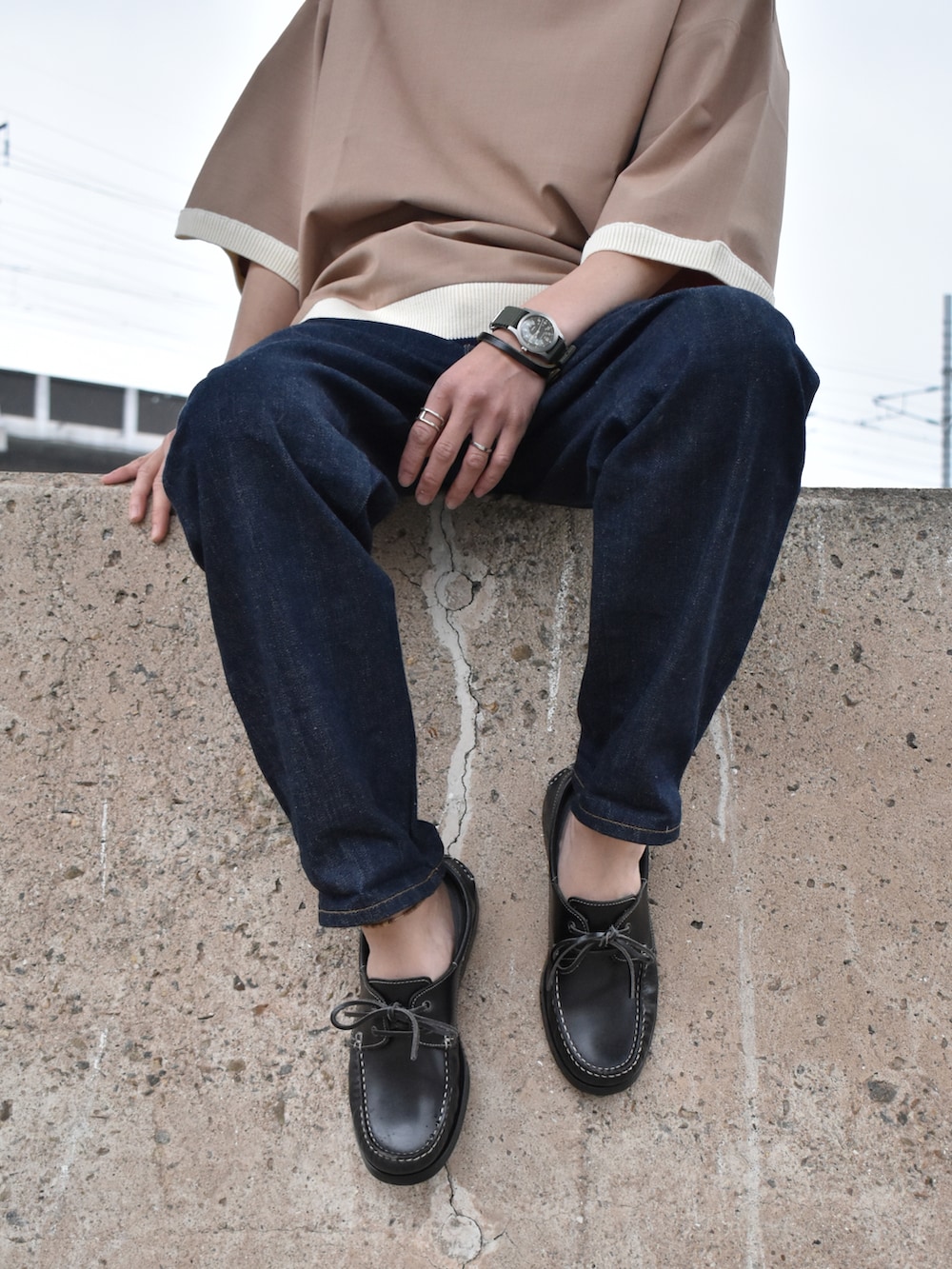 ベージュ系のTシャツ/カットソー、ブルー系のデニムパンツ、ブラック系のモカシン/デッキシューズを着用したメンズの春コーディネートの3枚目の写真