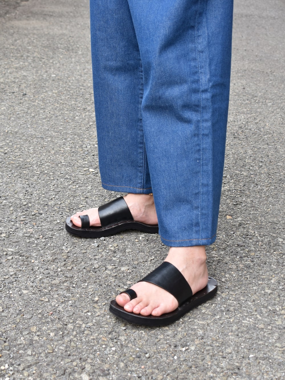 ホワイト系のTシャツ/カットソー、ブルー系のデニムパンツ、ブラック系のサンダルを着用したメンズの夏コーディネートの3枚目の写真