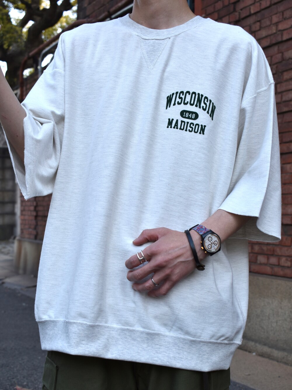 グレー系のTシャツ/カットソー、グリーン系のカーゴパンツ、ホワイト系のスニーカーを着用したメンズの春コーディネートの2枚目の写真