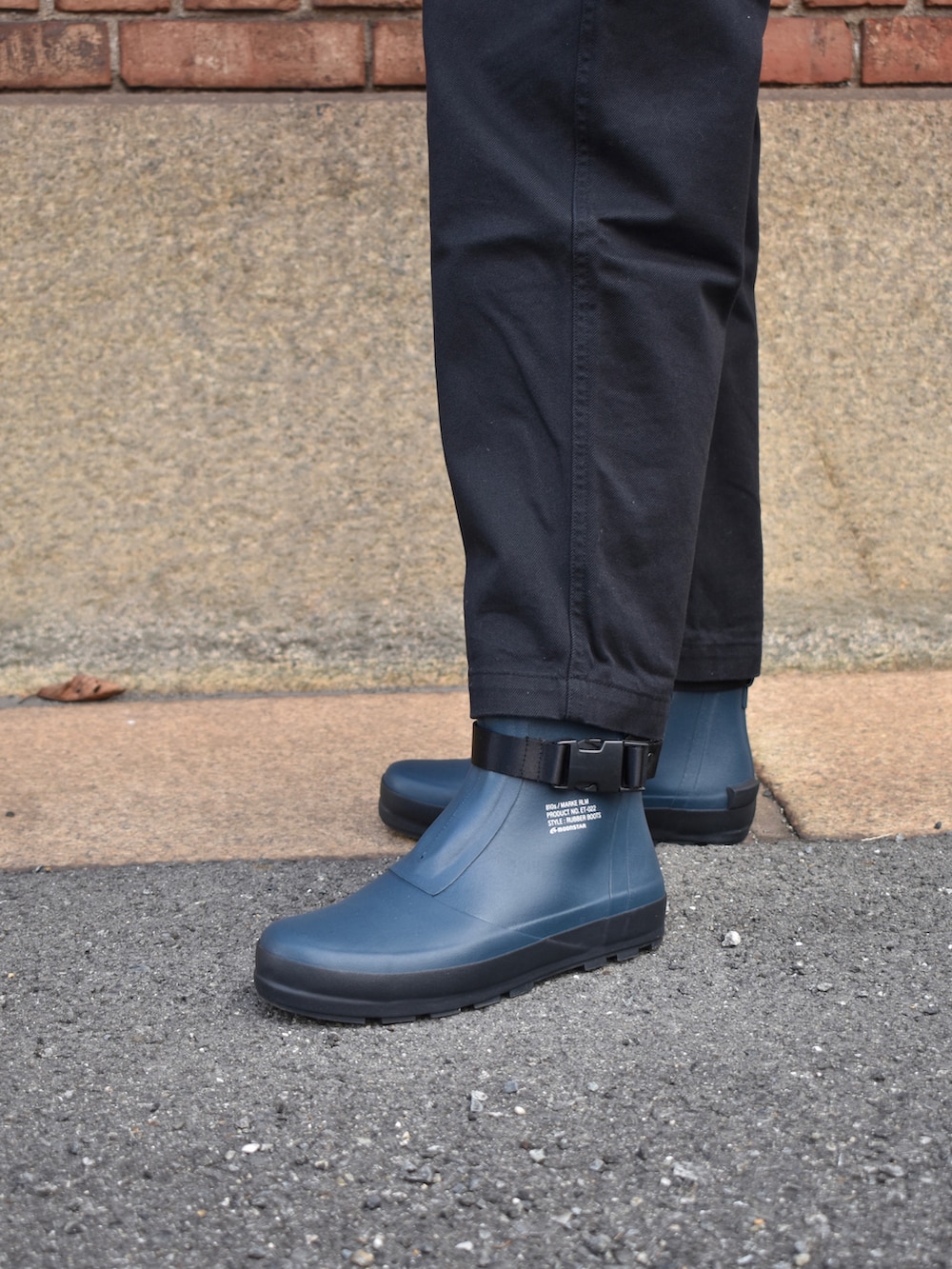 ブラック系のブルゾン、グレー系のチノパンツ、ブルー系のスニーカーを着用したメンズの冬コーディネートの2枚目の写真